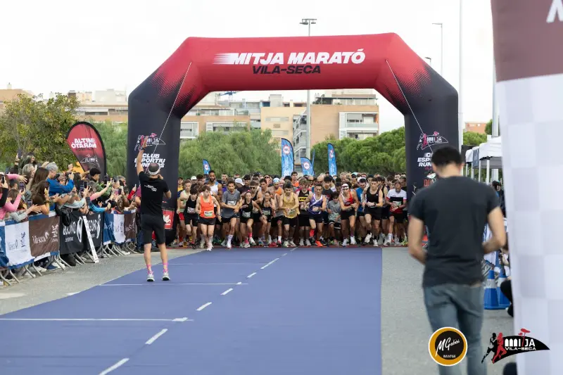 Sortida massiva de la Mitja Marató sota l'arc