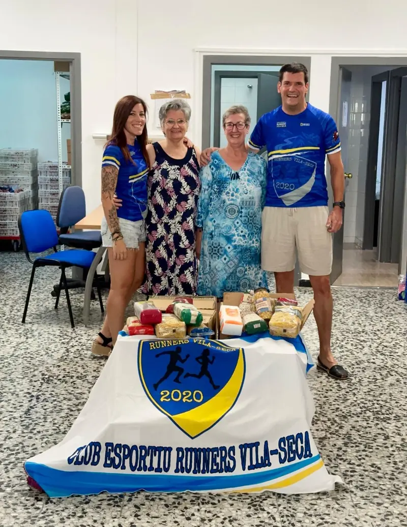 Membres del club amb la banderola al lliurament solidari d'aliments